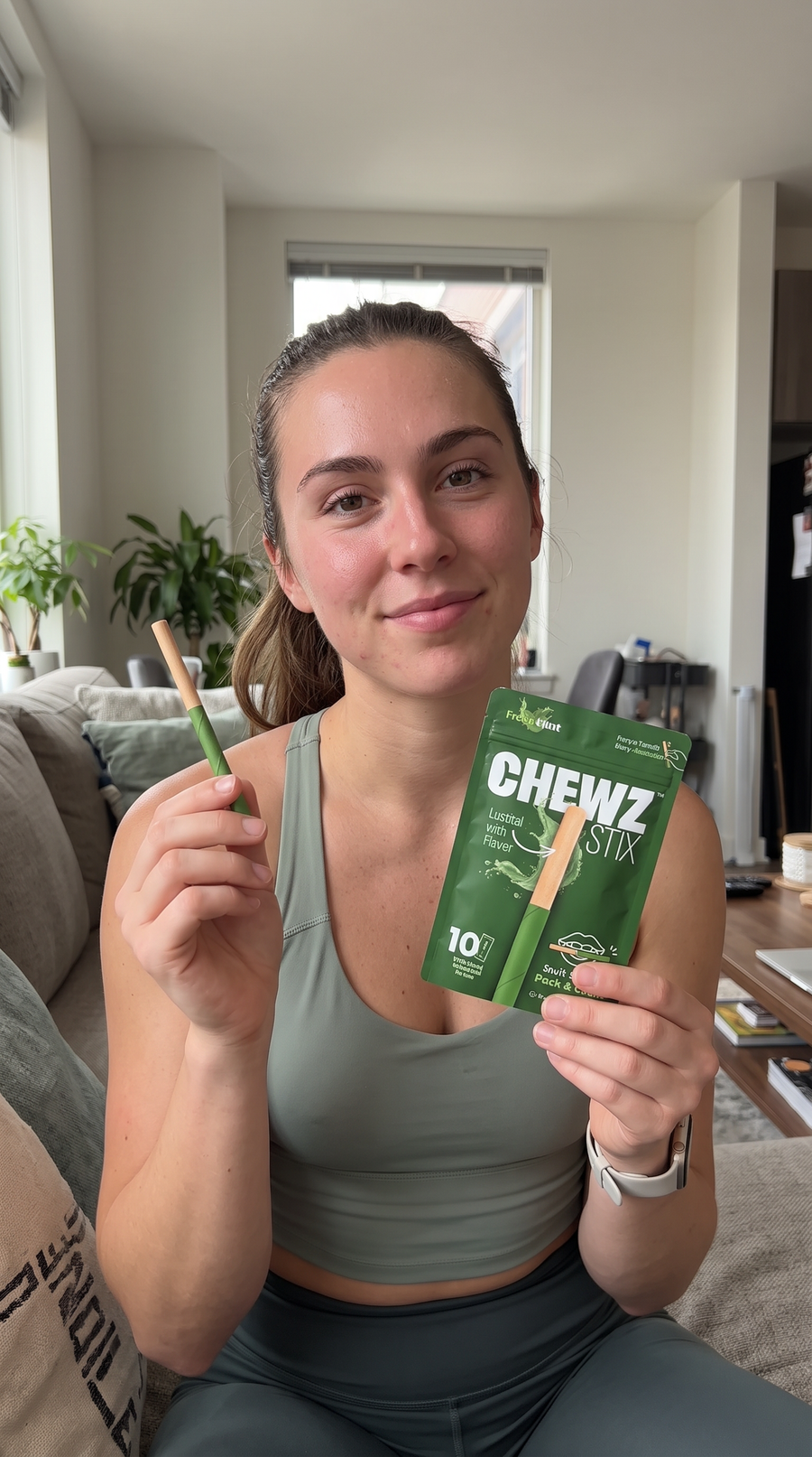 Person holding a CHEWZ STIX and Fresh Mint pouch at home