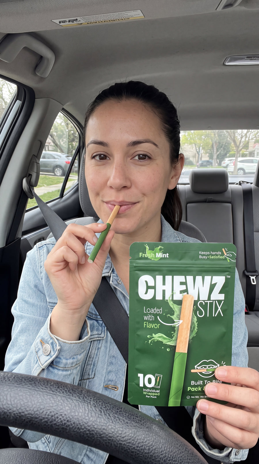 Person holding CHEWZ STIX and a Fresh Mint pouch in a parked car