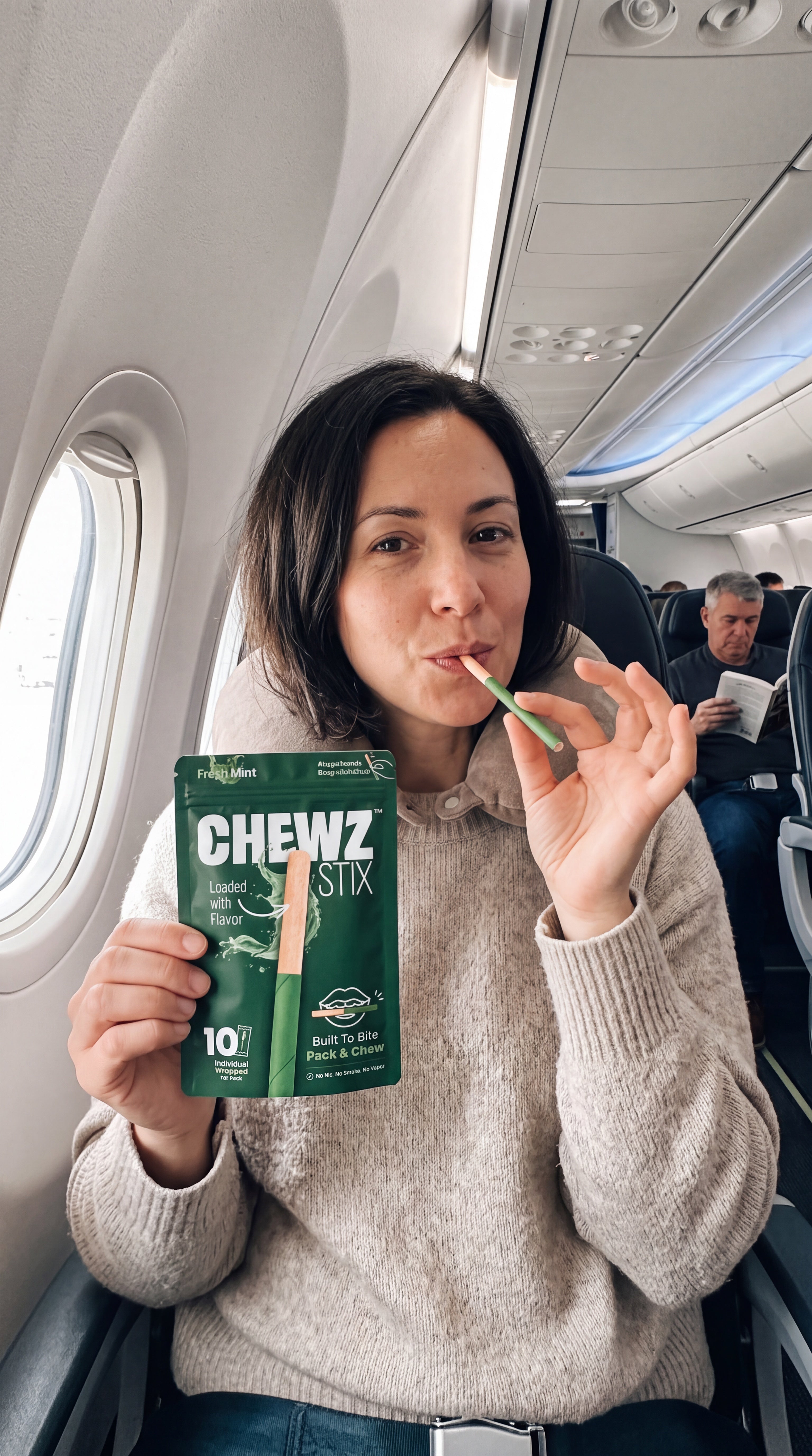 Person using CHEWZ STIX and holding a Fresh Mint pouch in an airplane seat